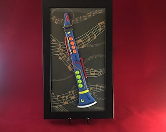 Fused Glass Clarinet, 11” tall multi colored instrument, framed in a 6.5 x 12” black frame