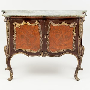 Puede incluir: Un mueble antiguo con tapa de mármol y detalles ornamentados. El mueble presenta un acabado de madera marrón rojizo con detalles dorados y tallas decorativas. Las patas son curvas y terminan en patas de garra.