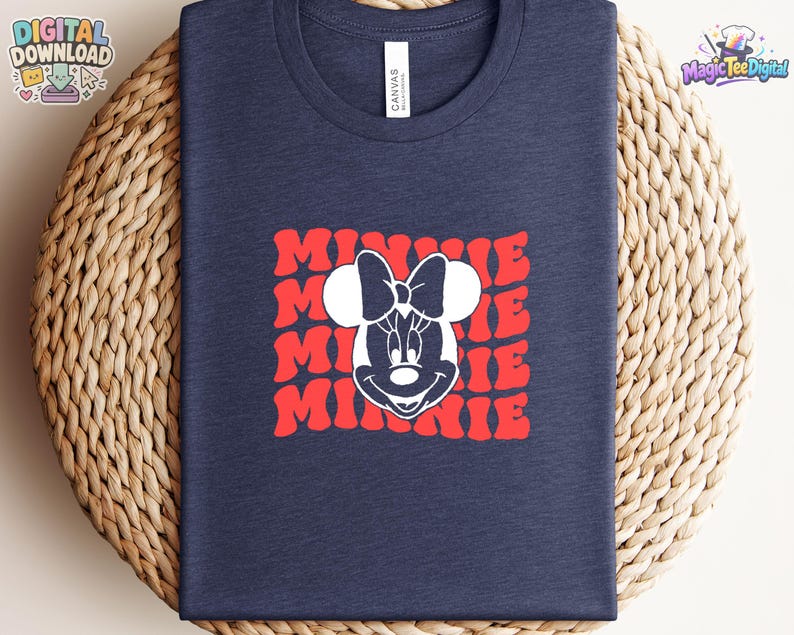 May include: A navy blue t-shirt featuring a white graphic of Minnie Mouse's face centered over a repeating red wavy text pattern that reads MINNIE. The shirt has a crew neckline and a standard fit, showcasing a clean and simple design aesthetic.