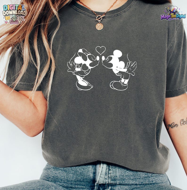 May include: A charcoal gray short-sleeve t-shirt featuring a white line art graphic of two cartoon mice leaning toward each other with a small heart positioned between their heads. The shirt has a crew neckline and a vintage-style washed finish.