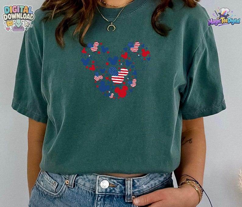 Puede incluir: Una camiseta de manga corta de color verde oscuro con un gr&aacute;fico central compuesto por varias siluetas peque&ntilde;as de orejas de rat&oacute;n en rojo, blanco y azul, con algunos patrones que recuerdan a la bandera estadounidense, combinada con vaqueros azules.