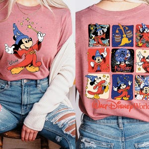 May include: A mauve long-sleeve t-shirt featuring Mickey Mouse as a wizard with a wand. The front of the shirt displays Mickey with a wand, while the back showcases a grid of Mickey Mouse images with the text "Walt Disney World".