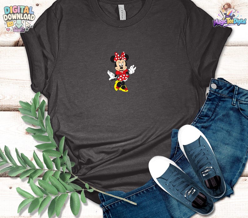 Peut inclure: Un t-shirt gris fonc&eacute; &agrave; manches courtes avec un motif central repr&eacute;sentant une souris de dessin anim&eacute; portant une robe &agrave; pois rouges et blancs, un n&oelig;ud assorti et des chaussures jaunes. Accompagn&eacute; d'un jean bleu et de baskets en toile bleu fonc&eacute;.