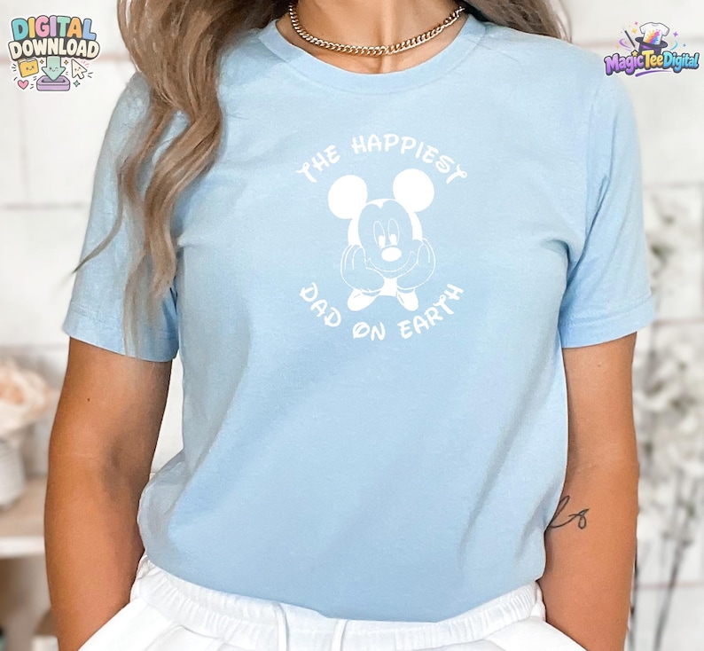 Puede incluir: Una camiseta de manga corta de color azul claro con un gr&aacute;fico blanco de un rat&oacute;n de dibujos animados con las manos en las mejillas. El texto "THE HAPPIEST DAD ON EARTH" est&aacute; impreso en una fuente blanca arqueada alrededor del dibujo.