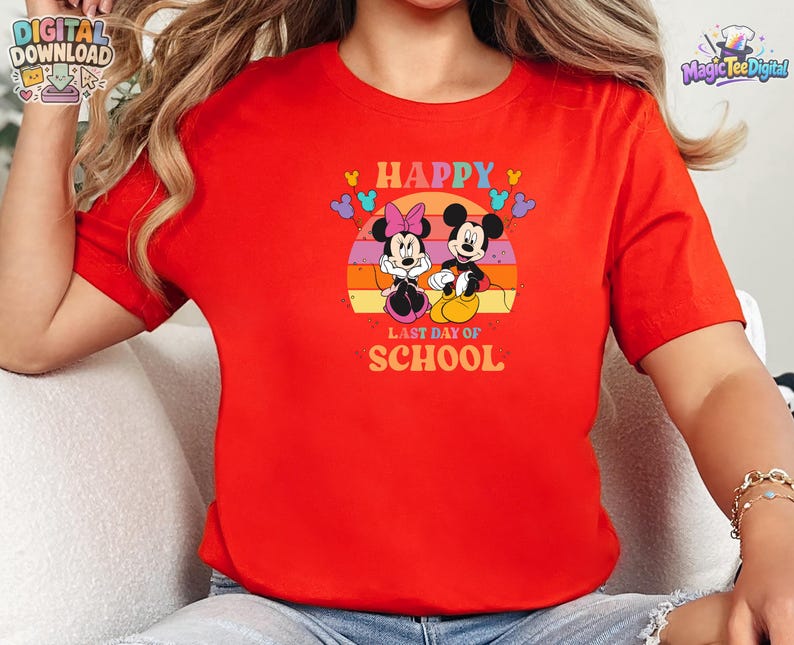 May include: A bright red short-sleeved t-shirt featuring a graphic of Mickey and Minnie Mouse. The design includes a sunset background, colorful balloons, and the text "HAPPY LAST DAY OF SCHOOL" printed in a bold, retro-style font on the front.
