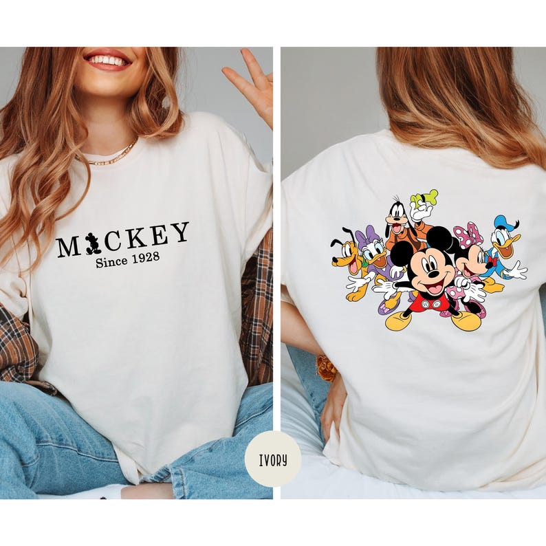 Puede incluir: Camiseta de color marfil con el texto "Mickey Since 1928" en la parte delantera. La parte trasera de la camiseta muestra un gr&aacute;fico colorido de Mickey Mouse y sus amigos. La camiseta es de estilo casual y c&oacute;modo.