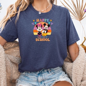 May include: A navy blue short-sleeve t-shirt featuring a graphic of Mickey and Minnie Mouse sitting in front of a retro-style orange and yellow sunset. The text "HAPPY LAST DAY OF SCHOOL" is printed in orange, with small colorful Mickey head icons.