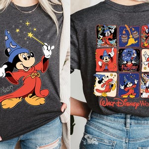 May include: Dark gray t-shirts featuring Mickey Mouse in a wizard costume. One shirt shows Mickey with a wand, the other displays a grid of Mickey Mouse images with "Walt Disney World" text.