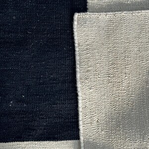 Macro view of flatweave wool kilim rug texture highlighting modern geometric Bauhaus style design and artisan craftsmanship