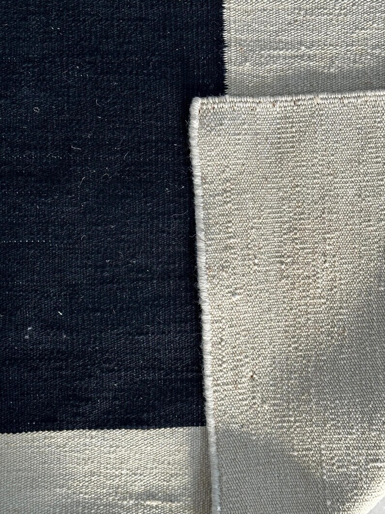 Macro view of flatweave wool kilim rug texture highlighting modern geometric Bauhaus style design and artisan craftsmanship
