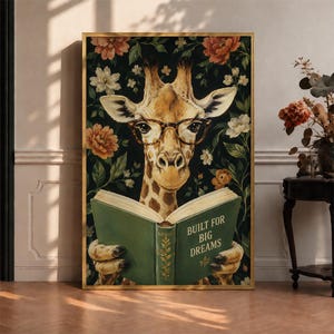 May include: A rectangular wall art print featuring a giraffe wearing brown-rimmed glasses, reading an open green book with the text BUILT FOR BIG DREAMS printed on the cover, set against a dark background filled with orange and white floral patterns.