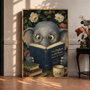 May include: A framed wall art print featuring a gray elephant wearing gold-rimmed glasses and reading a blue book titled The Elephant in the Room Embrace the Obvious. The scene includes a stack of books and a floral mug against a dark floral background.