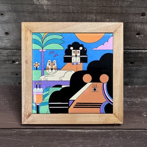 May include: Square art piece with a colorful, geometric illustration of a lion, a woman, and a palm tree. The artwork is set against a blue sky with an orange sun and framed in natural wood.