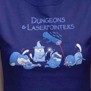 May include: A blue t-shirt with a graphic of cats playing Dungeons & Laserpointers. The text "Dungeons & Laserpointers" is printed in white on the shirt. The cats are wearing hats and holding wands and a laser pointer. The shirt is a deep royal blue color.