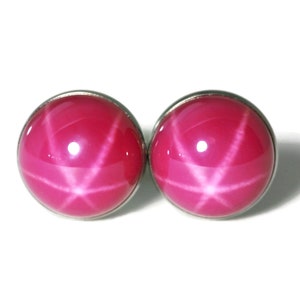 May include: A pair of silver stud earrings with pink star-shaped gemstones.