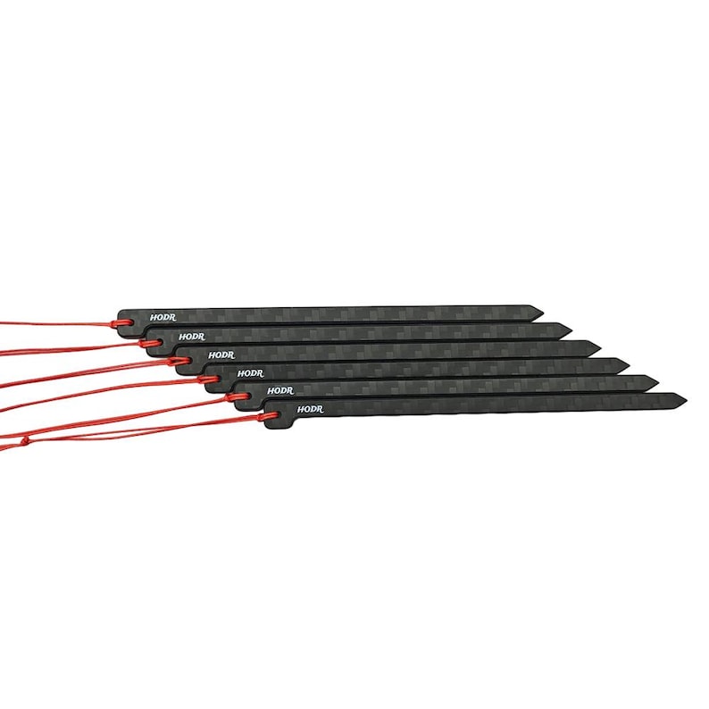 May include: A set of six black carbon fiber tent stakes with a checkered pattern, each featuring the text HODR printed in white. Each stake has a pointed end and a hole at the opposite end, through which a thin red cord is threaded and tied.