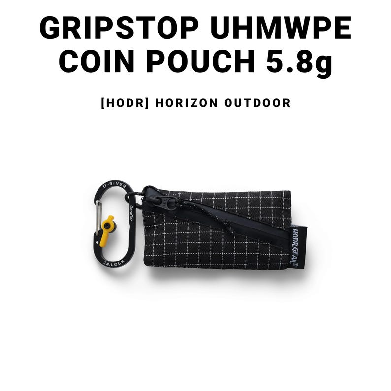 Pu&ograve; includere: Portamonete nero e bianco con motivo a griglia, cerniera nera e moschettone. Il testo "GRIPSTOP UHMWPE COIN POUCH 5.8g" &egrave; visualizzato sopra il portamonete. &Egrave; visibile anche il testo "[HODR] HORIZON OUTDOOR".