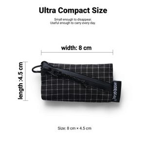Pu&ograve; includere: Una piccola pochette a scacchi bianchi e neri con cerniera nera. Misura 8 cm di larghezza e 4,5 cm di lunghezza. Il testo recita "Ultra Compact Size" e "Small enough to disappear. Useful enough to carry every day."