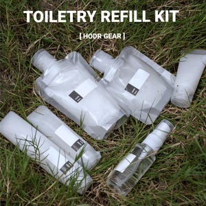 May include: A toiletry refill kit by HODR GEAR consisting of two clear flexible pouches, two translucent cylindrical bottles, and one clear spray bottle. Each container features a small black label with white text for identifying contents.