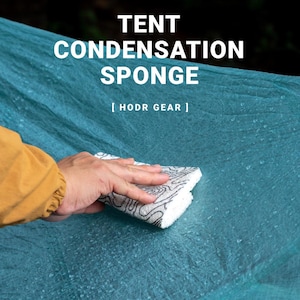 May include: A white tent condensation sponge with a black patterned design is being used on a teal tent surface. The text "TENT CONDENSATION SPONGE" and "[ HODR GEAR ]" are displayed in white.