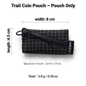 Pu&ograve; includere: Portamonete a scacchi bianchi e neri con cerniera nera e piccolo anello. Il portamonete misura 8 cm x 4,5 cm ed &egrave; etichettato come "Trail Coin Pouch - Pouch Only". C'&egrave; un'etichetta con scritto "HODR GEAR".