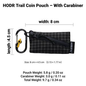 Pu&ograve; includere: Portamonete a scacchi bianchi e neri con cerniera nera e moschettone nero con un accento giallo. La borsa misura 8 cm di larghezza e 4,5 cm di lunghezza. Il testo "HODR Trail Coin Pouch - With Carabiner" &egrave; in alto.