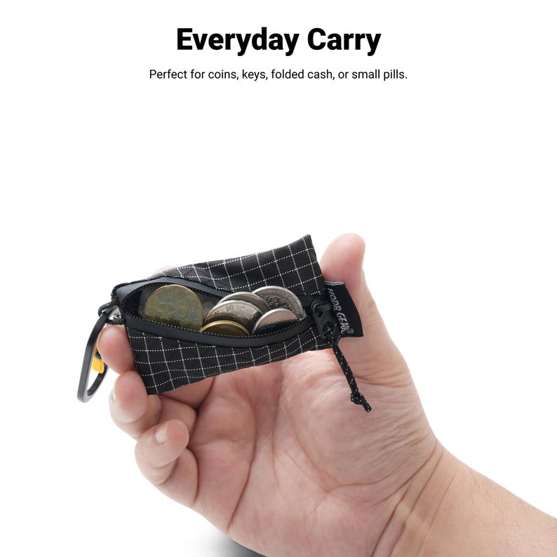 Pu&ograve; includere: Una piccola custodia a scacchi bianchi e neri con cerniera, contenente diverse monete. La custodia &egrave; tenuta aperta, mostrando il suo contenuto. Il testo "Everyday Carry" &egrave; in alto.