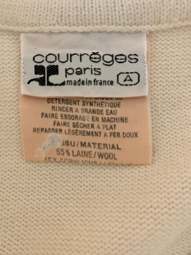 May include: White tag with black text that reads "courr&egrave;ges paris made in france" and a letter "A" in a circle. The tag also includes care instructions in French and the material composition: "55% LAINE/WOOL".