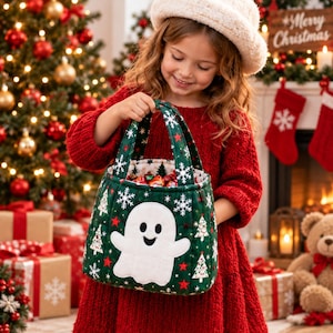 Peut inclure: Un panier en tissu matelassé vert foncé orné d'une applique de fantôme blanc, de petits flocons de neige blancs et d'étoiles rouges. Le panier possède deux anses en tissu assorties et contient des bonbons emballés, au design festif.