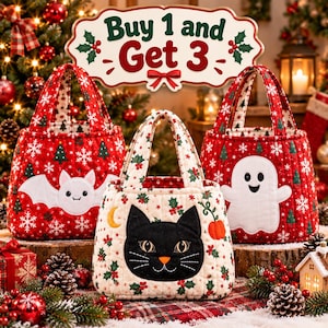 May include: Three quilted fabric bags featuring holiday motifs. The left bag is red with a white bat, the centre bag is cream with a black cat, and the right bag is red with a white ghost. A sign above reads Buy 1 and Get 3 with holly accents.
