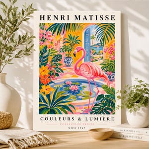 Puede incluir: Una lámina de arte rectangular titulada HENRI MATISSE COULEURS & LUMIÈRE COLLECTION PRIVÉE NICE 1947. La ilustración muestra un flamenco rosa brillante junto a un estanque azul circular con nenúfares rosas, rodeado de plantas tropicales.