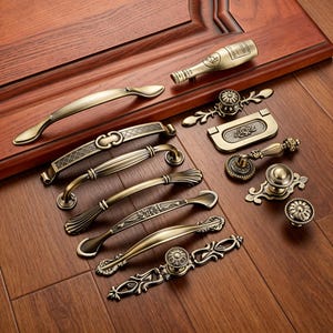 May include: A selection of antique brass door handles and knobs. The collection features various designs, including pull handles and decorative knobs, all with a vintage aesthetic. The hardware is displayed on a wooden surface.