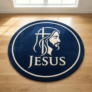 Può includere: Un tappeto rotondo blu navy con un bordo color crema. Il tappeto presenta un'immagine color crema di Gesù con una croce e la parola "JESUS" in grassetto.