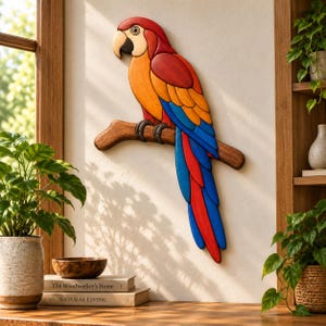 Può includere: Una scultura da parete in legno raffigurante un pappagallo dal design segmentato, con testa rossa, petto arancione e piume della coda blu e rosse. Il pappagallo è appollaiato su un ramo di legno marrone, mostrando dettagliata fattura e colori.