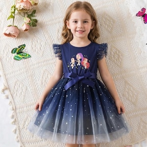 May include: A navy blue dress with a star pattern and a tulle skirt. The dress features a cartoon graphic and a matching bow. The dress has short, ruffled sleeves.