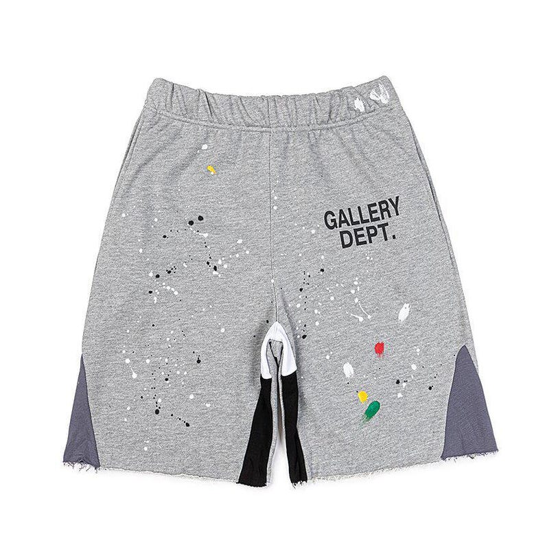 May include: Grey sweat shorts with a paint splatter design and the text "GALLERY DEPT." in black. The shorts have a drawstring waistband, black and white accents, and grey side panels.
