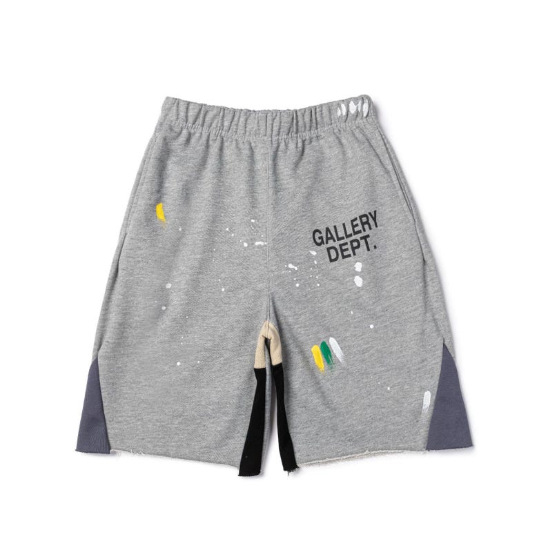 May include: Grey sweat shorts with paint splatter details and the text "GALLERY DEPT." The shorts have a raw hem, a drawstring waistband, and dark grey side panels. Paint colours include yellow, white, and green.