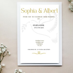 Op de afbeelding: Een witte trouwkaart met gouden details. Het kondigt de bruiloft van Sophia en Albert op 20.10.2026 aan. Het ontwerp bevat een duif en informatie over de locatie en receptie.