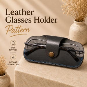 May include: A black leather glasses holder with a brass-colored snap button closure and blue stitching, containing a pair of glasses. The text reads Leather Glasses Holder Pattern, PDF Pattern, and Instant Download.