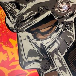 May include: A close-up of a silver and black helmet with a textured surface. The helmet is set against a red and orange background with graffiti-style markings.