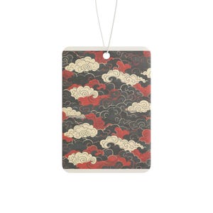 Könnte beinhalten: Ein rechteckiger hängender Lufterfrischer mit einem sich wiederholenden Muster aus stilisierten Wolken in Creme-, Dunkelgrau- und Dunkelrottönen. Das Design ist auf eine flache Oberfläche gedruckt, mit einem kleinen Loch oben für eine dünne weiße Kordel.