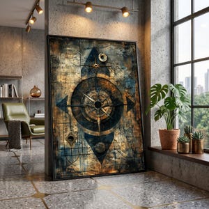 May include: Large framed artwork featuring a compass design with a distressed, textured appearance. The artwork incorporates shades of brown, blue, and gold, with a central compass rose and directional arrows. The piece is leaning against a concrete wall.