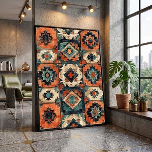 May include: Framed artwork featuring a geometric pattern in shades of orange, teal, and cream. The design is composed of repeating square tiles with stylized floral and star-like motifs. The artwork is displayed in a room with a window and plants.