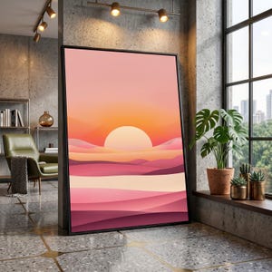 Peut inclure: Impression d'art encadrée représentant un coucher de soleil. L'œuvre d'art représente un grand soleil blanc se couchant sur des collines abstraites en couches dans des tons de rose, d'orange et de violet. L'impression est présentée dans un cadre noir.