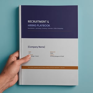 May include: A recruitment and hiring playbook with a navy blue and white cover. The title "RECRUITMENT & HIRING PLAYBOOK" is displayed in large, bold letters. The book is held by a hand against a light blue background.