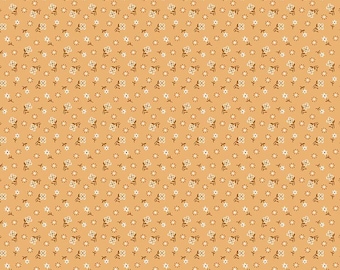 May include: A light orange fabric featuring a repeating pattern of small white flowers with brown centers and brown stems. A white ruler at the bottom shows a scale of 12 inches, with the text Riley Blake Designs printed on it.