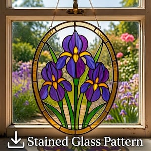 May include: Oval stained glass window art featuring three purple iris flowers with yellow centers and green leaves. The artwork is framed in gold and hangs in front of a window with a garden view. The text "Stained Glass Pattern" is at the bottom.