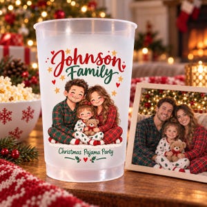 May include: A clear plastic cup featuring a printed illustration of a family in red and green plaid pajamas with a teddy bear. The text reads Johnson Family and Christmas Pajama Party, surrounded by small red hearts and gold stars.