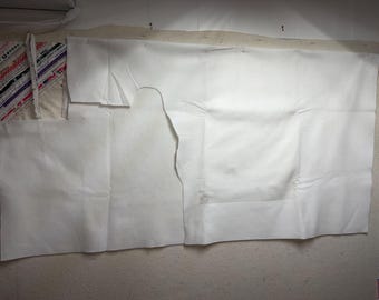 Tela de fieltro blanco de 71” x 74”, corte irregular, mancha sucia.
