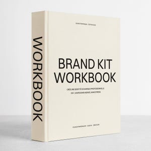 Peut inclure: Un "Brand Kit Workbook" de couleur crème avec du texte noir. Le titre est bien en évidence, avec "Workbook" verticalement sur le dos. Le sous-titre et les informations sur l'auteur du livre sont également visibles.